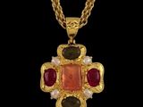 une photo d'un collier en or orné d'une pierre rouge et de perles