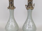 une paire de lampes anciennes en verre avec des pieds en laiton, sur fond blanc