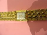 an image of a close up of a wrist watch on a pink surface
