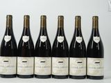 six bouteilles de vin sont alignées sur une table