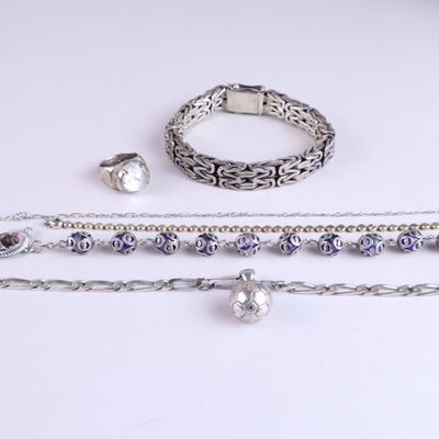 three pieces of silver jewelry on a white surface