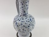 a blue and white vase with a handle on a stand