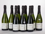 six bottles of wine lined up in a row on a white surface