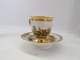a cup and saucer with a picture of a house on it