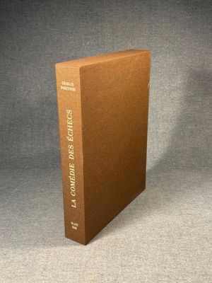 a brown book sitting on top of a table next to a gray wall