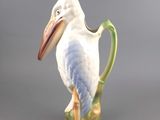 a white bird sitting on top of a green cup