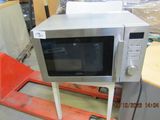 a microwave that is sitting on a stand in a warehouse