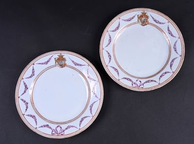 deux assiettes blanches ornées de bordures dorées et d'un motif violet et blanc