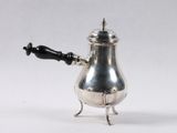 an antique silver coffee pot with a black handle on a white background