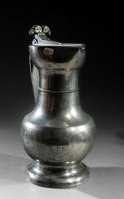 a silver vase sitting on a table with a black background