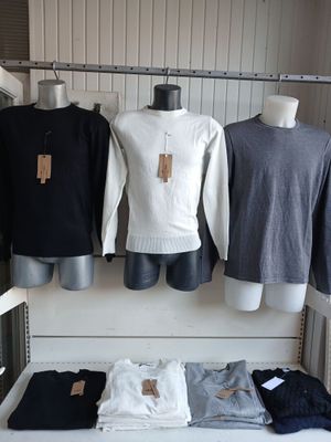 three mannequins and three shirts on display in a store