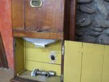 une armoire en bois avec un tiroir, placée dans un coin de la pièce