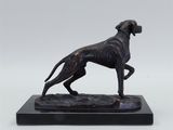 a bronze statue of a dog on a marble base
