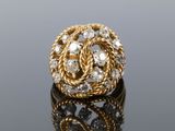 a close up of a gold and diamond ring on a reflective surface