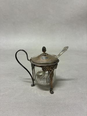 une théière en métal argenté contenant une cuillère et une cuillère