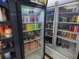 deux réfrigérateurs remplis de boissons dans un magasin