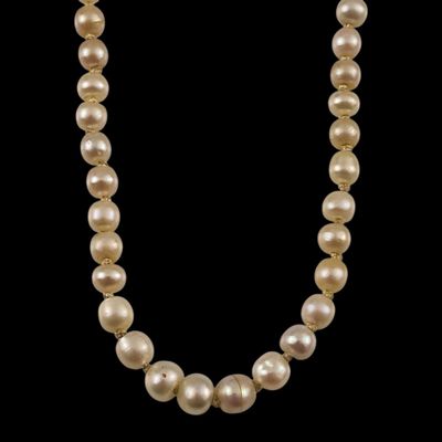 un collier de perles blanches sur fond noir