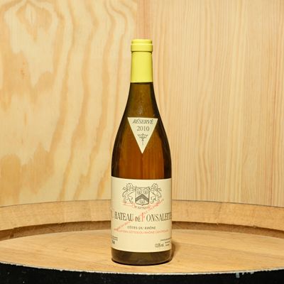 a bottle of wine sitting on top of a wooden barrel