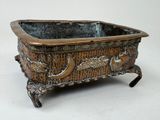a small metal planter that is sitting on a table