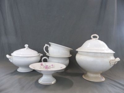 cinq pièces de porcelaine blanche exposées sur une table