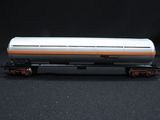 an orange and white train car sitting on top of a black surface