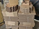 une pile de cartons posée sur une palette devant un mur de briques