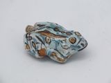 a small blue and brown bead on a white surface