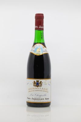 a bottle of red wine sitting on top of a white table