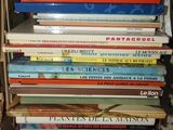 many books stacked on top of each other on a shelf