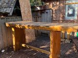 une table en bois sur une terrasse en bois devant une maison