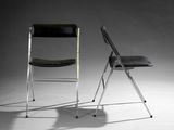 pair of black folding chairs against a gray background