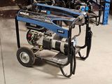 un petit générateur bleu posé sur un chariot dans un garage