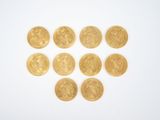 several gold coins arranged in the shape of a heart on a white surface