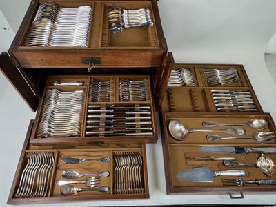 many different types of silverware in a wooden box