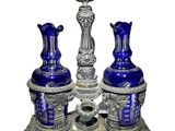 two blue vases sitting on a silver stand
