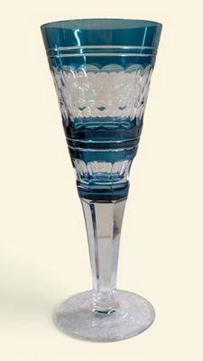 un verre à vin bleu posé sur une table blanche