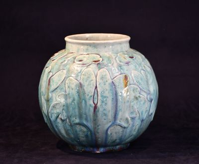 un vase bleu posé sur une surface noire