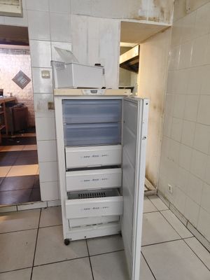 un réfrigérateur ouvert au milieu d'un sol carrelé