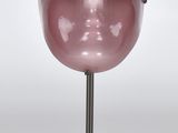masque facial rose posé sur un support, sur fond blanc, avec un fond blanc
