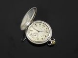 an old silver pocket watch sitting on top of a black surface