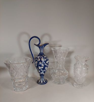 un vase bleu et blanc posé sur une table, à côté d'autres objets en verre