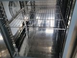 an open oven that is sitting on a tiled floor