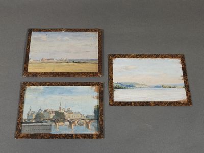 three paintings on a table with a picture of a bridge in the background
