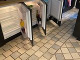 a small refrigerator that is open on the floor