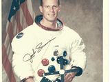 une vieille photo d'un homme en combinaison d'astronaute tenant un drapeau américain