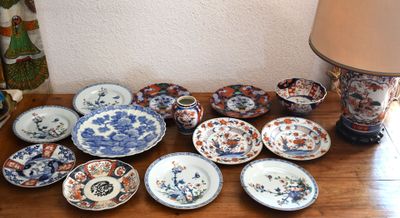 many plates and bowls sitting on a table with a lamp