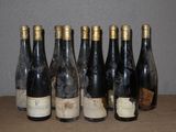 Six bouteilles de vin sont alignées sur une table devant un mur.
