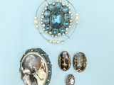 three pieces of jewelry including a broochle, earrings, and a ring