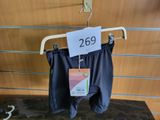 a sign on a hanger with a pair of pants on it