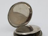 a silver pocket watch with a red string around it
